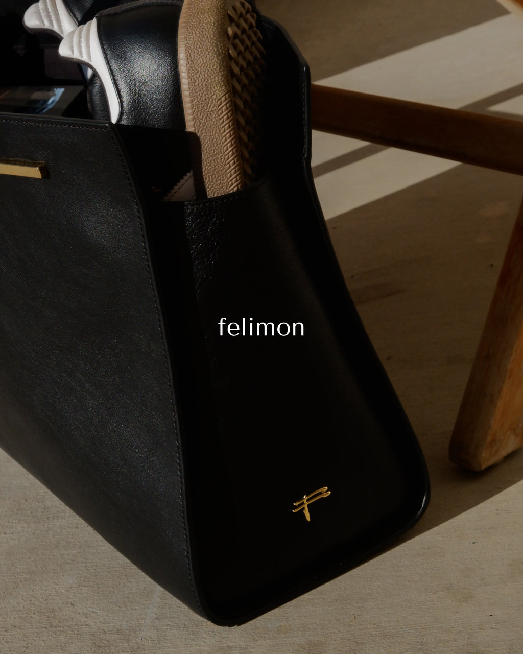 Black cowhide leather tote bag with gold hardware — the Take Me With You carryall by Felimon, designed for everyday use and timeless style.